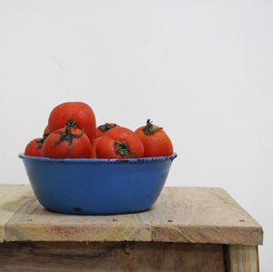 Fruits in bowl on table against white background