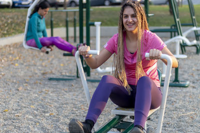 Mom and daughter using equipment outdoor in the communication with the workout, healthy lifestyle