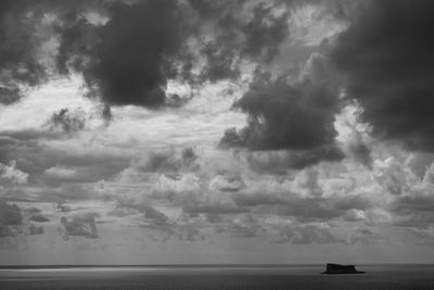 Scenic view of sea against storm clouds