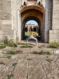 Woman sitting on old building