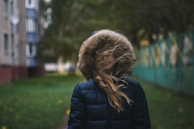 Girl in fur coat standing outdoors