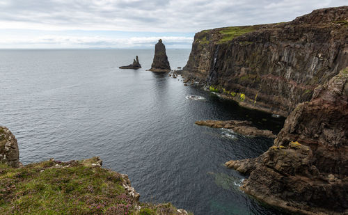 Scenic view of rocks on sea against sky