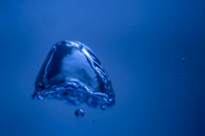 Close-up of water drop against blue background