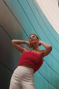 Full length of young woman  stands near a mirrored wall