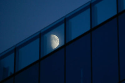 Low angle view of moon against blue sky at night