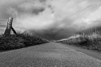 Road amidst field against sky