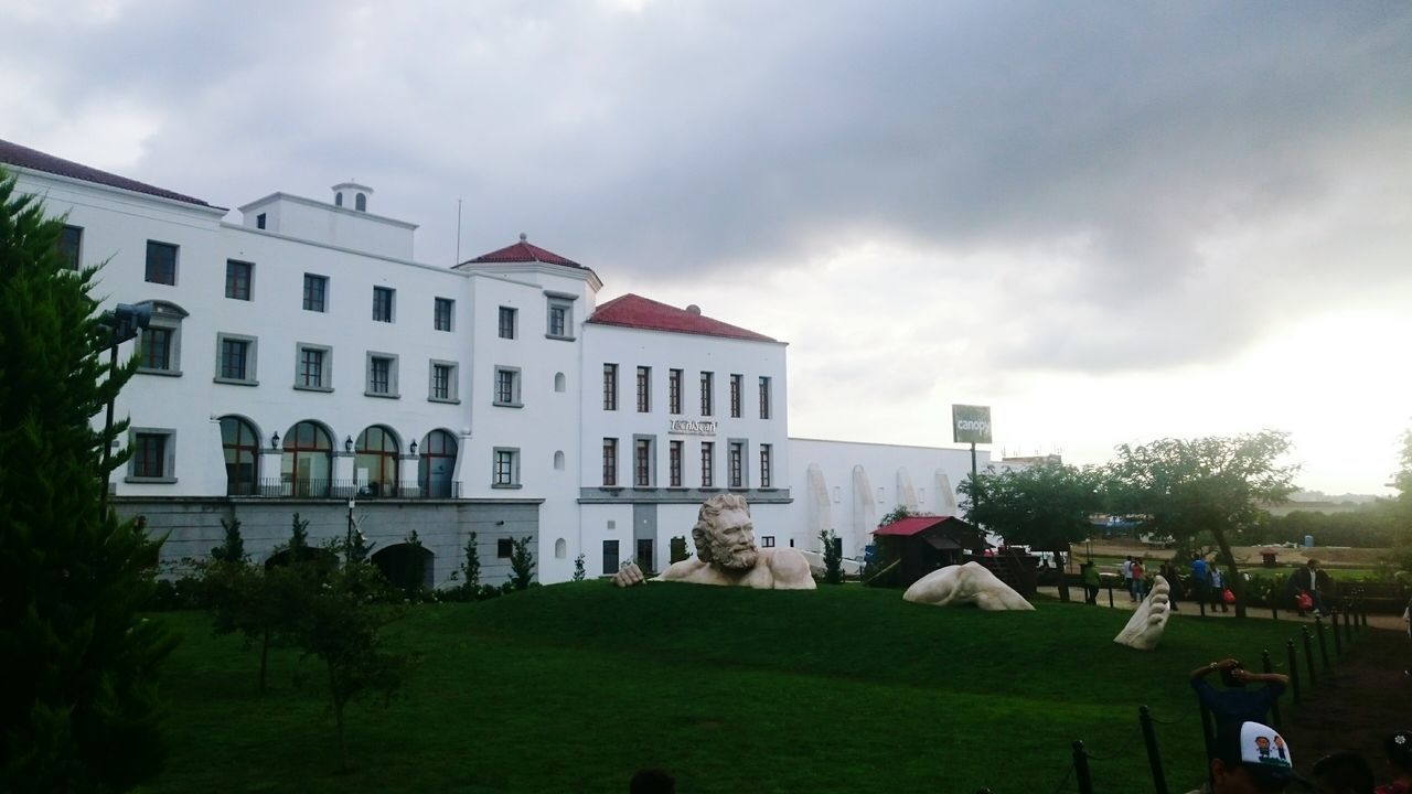 architecture, building exterior, built structure, cloud - sky, sky, city, cloud, cloudy, lawn, travel destinations, city life, day, outdoors, garden, green color, facade, in front of, cloudscape, building story, storm cloud, development, formal garden