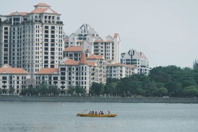 Boats in river with buildings in background