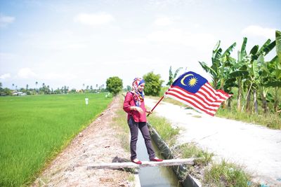 Woman standing on field against sky