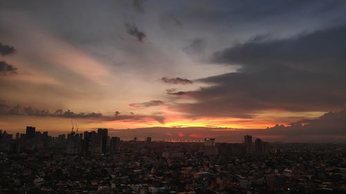 Aerial view of buildings against sky during sunset