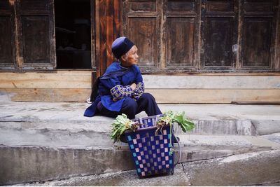 Full length of woman sitting in basket