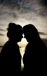 Silhouette couple against sky during sunset