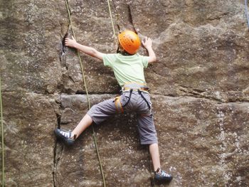 Full length of man climbing rock