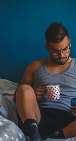 Midsection of man sitting on bed