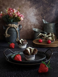 Close-up of cupcake and strawberries on table