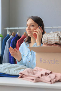 Side view of young woman using mobile phone at home