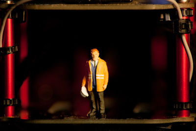 Portrait of man standing in illuminated shop