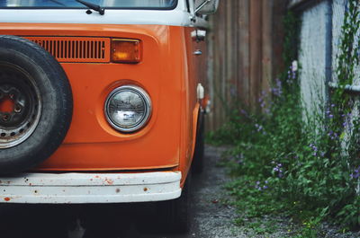 Old orange van parked by building