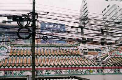 Low angle view of electricity pylon on building