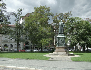 Statue by street against buildings in city