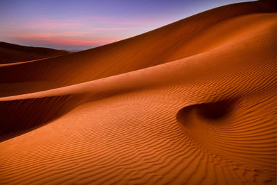 Scenic view of desert against sky during sunset