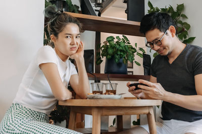 Portrait of young woman sitting on table