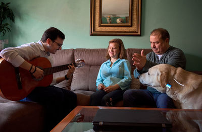 Family having fun while they're playing the guitar and singing at home