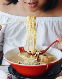 Close-up of woman eating noodles