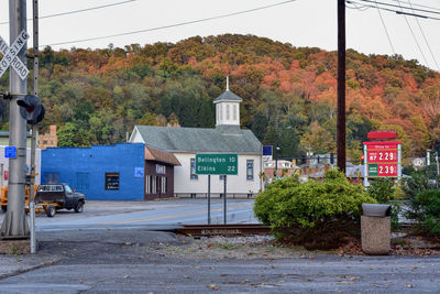 Road by buildings in city against sky