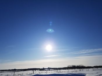 Scenic view of snow covered landscape against blue sky