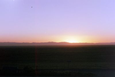 Scenic view of field against clear sky during sunset