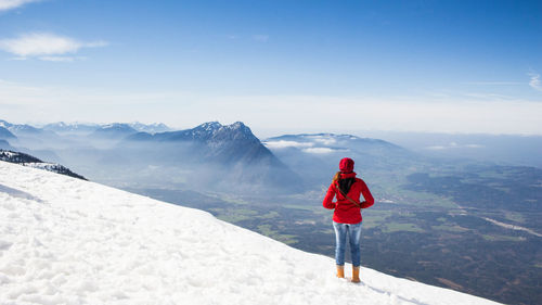 Rear view of man standing on snow covered landscape