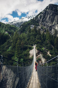 Footbridge over mountains against sky