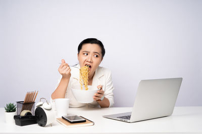 Portrait of young man using laptop on table