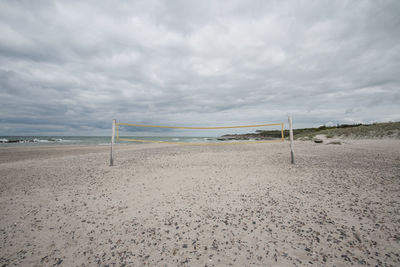 Scenic view of beach against cloudy sky