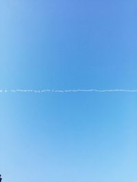 Low angle view of trees against clear blue sky