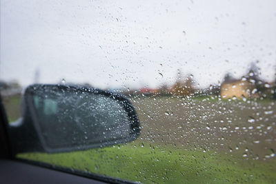 Close-up of wet car window during rainy season