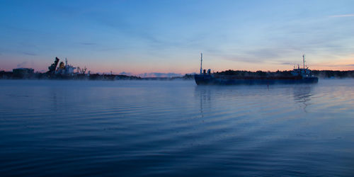 Boat moving on sea during foggy weather at dusk