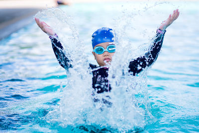 Happy children smiling cute little girl in sunglasses in swimming pool.