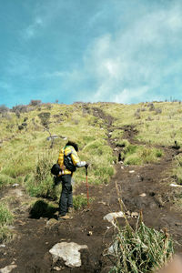 Full length of man standing on mountain against sky