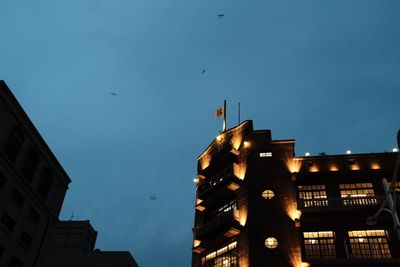 Low angle view of illuminated building against blue sky