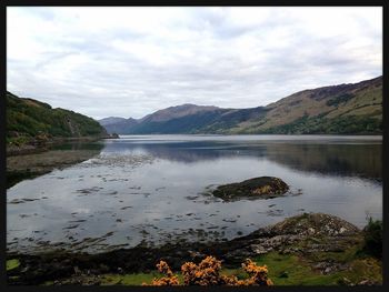 Scenic view of lake against cloudy sky