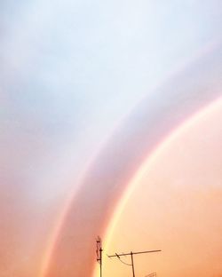 Low angle view of rainbow against sky during sunset