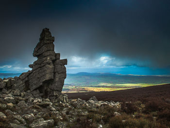 Rock formation on landscape against sky