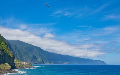 Scenic view of sea and mountains against sky