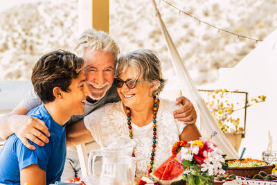 Senior parents with teenage boy sitting in patio