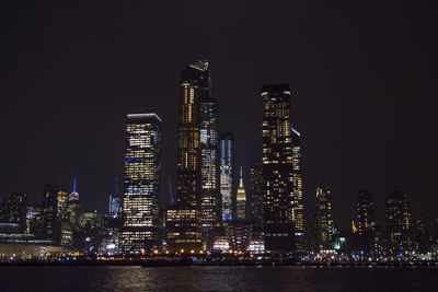 Illuminated buildings against sky at night