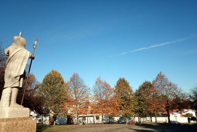 Panoramic view of trees and buildings against blue sky