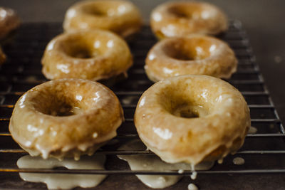 Iced doughnuts fresh out of the oven cooling on a wire rack