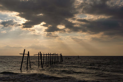 Silhouette pier on sea against sky at sunset